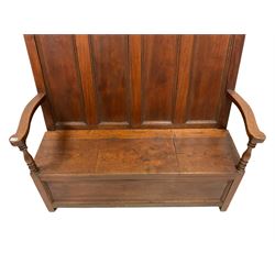 20th century oak settle, the four panelled back over seat with hinged lifting lid, raised on square supports W146cm, H136cm, D63cm  