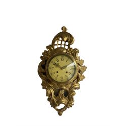 A mid 20th century wooden gilt painted cartel clock in the French 18th century Rococo style, cream painted dial with Arabic numerals recording both the hours and five-minutes, gilt Louis XV style hands and minute track within a brass bezel and convex glass, with a twin train spring driven pendulum movement striking the hours on a bell. With pendulum. 

