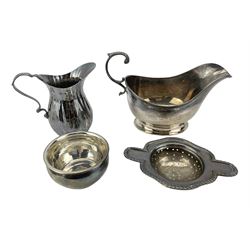 Silver sauce boat with C scroll handle Birmingham 1940 Maker Adie Brothers, small silver cream jug and a silver tea strainer on an associated stand