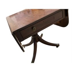 Regency mahogany drop-leaf supper table, rectangular top with rounded corners and ebony stringing, reeded edge, fitted with single cockbeaded oak lined drawer with brass handles and opposing faux drawer, raised on turned pedestal with quadripod base the splayed sabre supports terminating in brass cups and castors