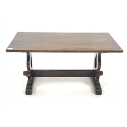 Rectangular oak coffee table, with pierced and shaped panel end supports with sledge feet, united by pegged stretcher 