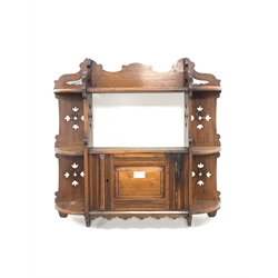 Late Victorian walnut wall hanging shelf and cupboard, with pierced fret cut decoration and single panelled cupboard door 