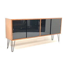 Mid century teak sideboard, fitted with four black lacquered glazed sliding doors enclosing adjustable shelves, raised on hairpin supports, W183cm, H85cm, D39cm