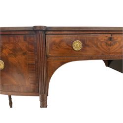 George III mahogany bow front sideboard, the shaped top with reeded edge, fitted with central frieze drawer, the bookmatched veneer front with ebony and satinwood stringing and gilt metal rosette ring handles, flanked by two cupboards with crossbanding and geometric stringing, raised on tapered reeded pillister supports 