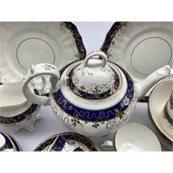 19th century English porcelain tea set, decorated with gilt sprigs of grape and vine and with cobalt blue bands, comprising teapot, sucrier, jug, slop bowl,  seven teacups, eleven saucers and two serving plates, no. 398