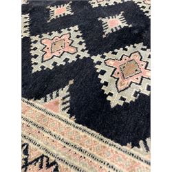Persian design ground rug, black field with repeating lozenge medallions enclosed by multi lined boarder. 126 x 203cm.
