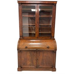 Victorian mahogany cylinder front bureau bookcase, moulded cornice over two glazed doors, the cylinder roll top opens to reveal sliding writing surface with leather insets, small drawers and pigeon holes, two panelled cupboards below with upright pilasters, on skirted base