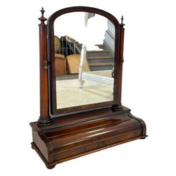 Mid-19th century mahogany toilet mirror, the arched mirror in chamfered slip and supports by two tapered columns with finial, the piano lid front hinges to reveal compartment, lower mould on compressed bun feet