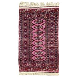 Persian Bokhara violet ground rug, the field with a row of eight Gul motifs surrounded by a heavily guarded border containing repeating geometric designs
