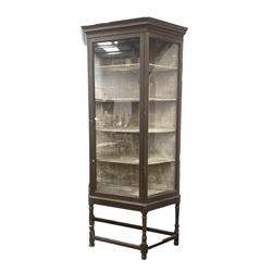 Large early 20th century oak shop display cabinet, with glazed canted sides and door enclosing a crushed velvet lined interior with four shelves, raised on stand with turned supports and stretchers W120cm, H233cm, D44cm