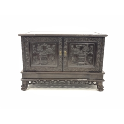 Late 19th century Chinese carved rosewood two door cupboard, profusely carved  with trailing leaf scrolls, rosed, urns and humming birds, raised on ball and claw feet, W111cm, H77cm, D53cm  