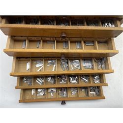 An eight drawer printers chest containing a quantity of metal stamps/ matrices, H32cm, W31.5cm, D20.5cm