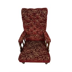 Victorian style armchair, upholstered in floral fabric, raised on turned supports 