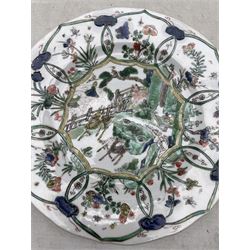 Chinese Kangxi porcelain plate decorated in Famille Verte enamels with three deer on a fenced veranda, Ding incense burner mark beneath D22cm, and another Chinese Famille Verte plate with Conch shell mark beneath (2)