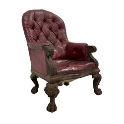 Victorian oak framed library armchair, arched back in buttoned red leather, scrolled arm terminals and uprights carved with acanthus leaves, serpentine seat, acanthus carved ball and claw feet