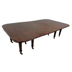 19th century mahogany dining table, rectangular moulded top with rounded corners, two D-ends each on five turned and reed carved supports with brass cups and castors, pull-out extension supports, with two additional leaves