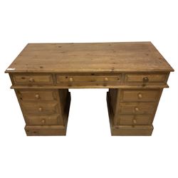 20th century traditional pine twin pedestal desk, fitted with nine drawers with turned handles, on skirted base