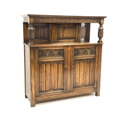 Early 20th century oak court cupboard, moulded cornice above scroll carved frieze, turned and carved cup and cover supports, cupboard with linen fold panelled door and sides, double cupboard below enclosed by two doors with lunette and linen fold panels, W143cm, H151cm, D50cm