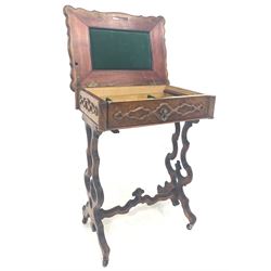 Victorian walnut sewing table the serpentine moulded top lifting to reveal fitted interior, drawer to frieze with applied carved moulding, raised on shaped and pierced panel end supports united by a wavy stretcher W55cm