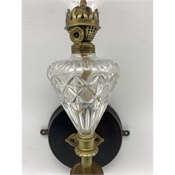 Edwardian wall mounted oil lamp, with brass mounts and oil reservoir of graduated form H57cm