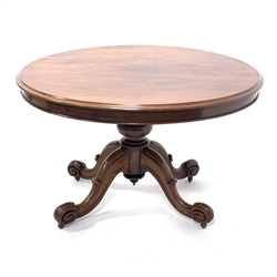 Victorian mahogany breakfast table, circular moulded tilt top on turned pedestal, four shaped out splayed supports with scroll carved terminals, brass and ceramic castors, D119cm, H74cm