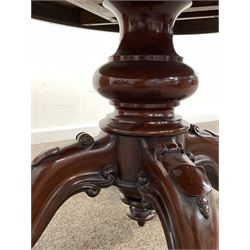 Victorian mahogany loo table, the oval tilt top over baluster turned column and four out played supports carved with scrolls and shields, raised on castors 146cm x 107cm, H75cm
