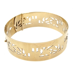 Gold hinged bangle with openwork decoration stamped 9ct, approx 19.78gm