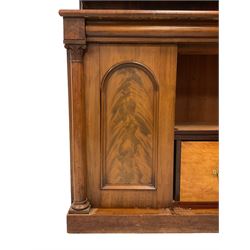 19th century mahogany chiffonier, the raised shaped back with scrolled foliate and central cartouche carved decoration, raised graduating two tier shelf on scrolled supports, rectangular top over frieze drawer and double cupboard, figured and arch panelled doors, turned upright pilaster columns with foliate capitals, on plinth base