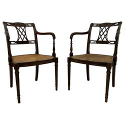 Pair Hepplewhite design open elbow chairs, the cresting rail carved with extending bellflower festoon and central flower head motif, the back with pierced interlacing lattice and trailing splat joining the cresting and middle rail, moulded frame with turned arm supports, shaped cane-work seat on turned and fluted supports