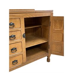 'Oakleafman' oak dresser base, all-over adzing, fitted with four drawers and two cupboards, wrought metal fittings, panelled doors and sides, the left-hand side carved with leaf signature, by David Langstaff of Easingwold