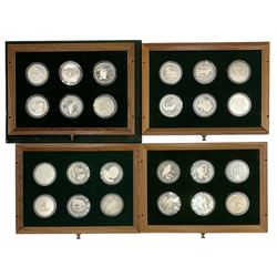 The 'Conservation Coin Collection', comprising twenty-four silver proof coins, housed in a wooden display case, each coin approximately 28 grams
