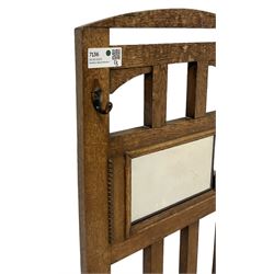Edwardian oak hall stand, raised mirror back with flanking coat hooks, over umbrella or stick stand with drip trays to base