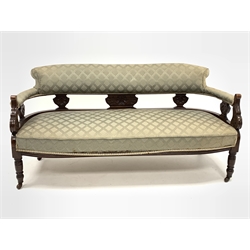  Late Victorian carved walnut framed three seat salon sofa, upholstered in patterned green fabric, raised on turned supports and ceramic castors, W156cm  