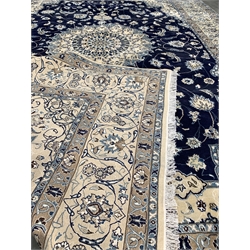 Persian ivory ground carpet, central medallion on blue field decorated with interlaced foliate