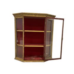Late 19th century gilt framed wall display cabinet, the projecting cornice moulded with egg and dart decoration, fitted with five glazed panels and a central door, enclosing two gilt shelves