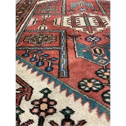 Persian design red ground rug, with stylised geometric and floral decoration on red field, 112cm x 150cm