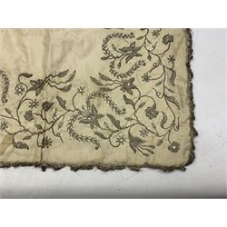 19th century silk embroidered panel or table runner, embroidered in silvered metal thread with scrolling foliage and fringed border, 112cm x 54cm, together with a bright embroidered panel, possibly Turkish and another (3)