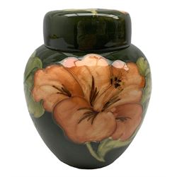 Moorcroft 'Coral Hibiscus' pattern ginger jar and cover, pink decoration on green ground, with painted mark and sticker to base
