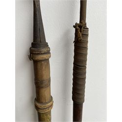 Pair of African carved wooden paddle clubs, African hide shield, Zulu and other spears and a long bow with incised decoration L133cm (11)