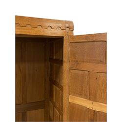Mouseman - panelled and adzed double wardrobe, arcade carved top rail over two panelled doors, with wrought metal hinges and latch, relief carved mouse signature, the interior fitted with hanging rail, by the workshop of Robert Thompson, Kilburn