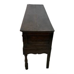 18th century oak dresser base, rectangular top with moulded edge, fitted with three drawers with scrolling foliate carved facias, shaped waived apron, raised on turned front supports