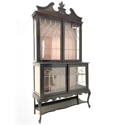 Late 19th century mahogany Empire style display cabinet, swan neck pediment and carved urn finial over two lead glazed doors enclosing two shelves, two glazed doors under, raised on cabriole front supports W123cm, H240cm, H45cm