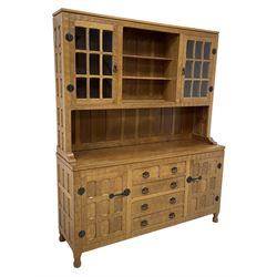 Yorkshire Oak - adzed oak dresser, raised shelves and display cabinets enclosed by glazed doors, the dresser fitted with two short and three long drawers flanked by cupboards, panelled doors and sides, wrought metal fittings 