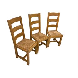 Solid light oak rectangular extendable dining table, fitted with single drawer and raised on square supports, with two additional leaves (W150 D85 H78); and six ladder back dining chairs with rush seats (W47 D43 H104)