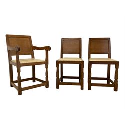 'Oakleafman' set five oak dining chairs, panelled backs, the seats upholstered in cream leather with stud band, octagonal front supports joined by stretchers, the front stretchers carved with leaf signature, four side chairs and one carver, by David Langstaff of Easingwold