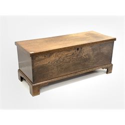 Early 20th century oak blanket box, hinged lid revealing interior fitted with four trinket drawers and candle tray, raised on shaped bracket supports W125cm, H52cm, D50cm