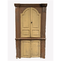  Early 19th century pine corner cupboard, dentil cornice over two arched panelled doors enclosed by fluted pilasters, two panelled doors under, W114cm  