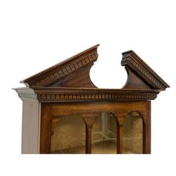 Georgian design mahogany cabinet, the broken sloped arch and dentil cornice over glazed door enclosing lined interior, fitted with two drawers and double cupboard, on bracket feet