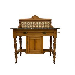 Late Victorian walnut framed washstand, raised back with scallop pediment over five tiles with flower head decoration, the rectangular marble top over single drawer and small cupboard, raised on ring turned supports terminating in ceramic castors