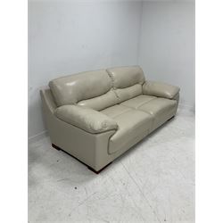 Contemporary three seat sofa, upholstered in cream leather and raised on block supports (W220cm) together with a matching armchair (W120cm)
